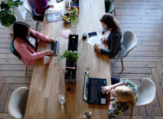 Aerial View of 3 Women Sitting at a Distressed Table